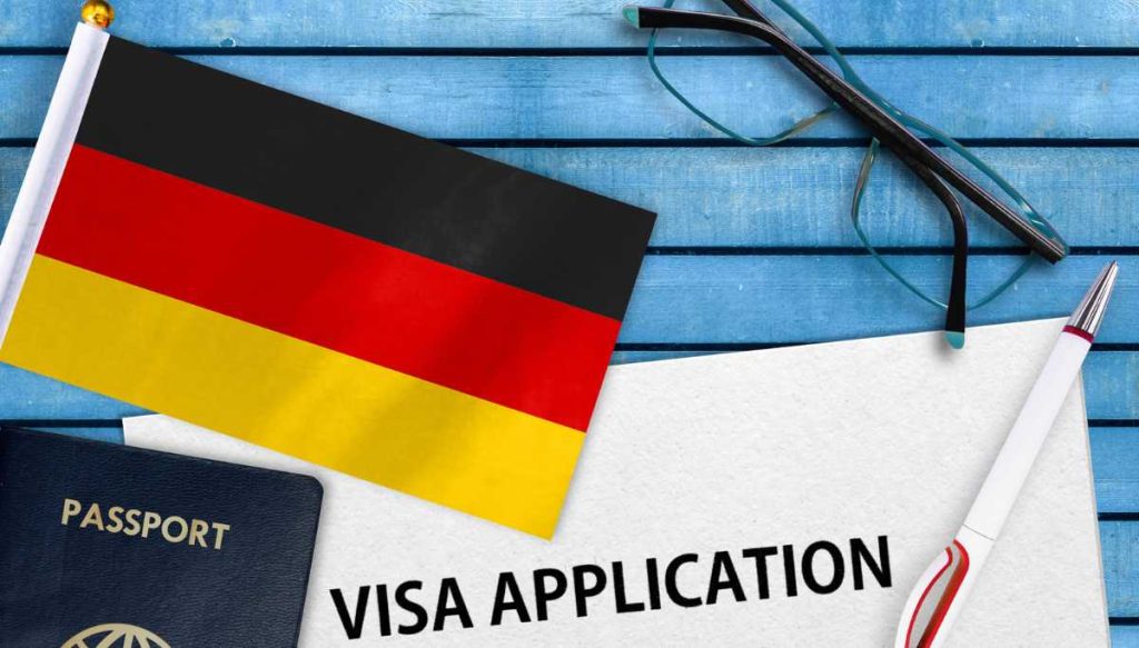 پرچم آلمان، عینک، پاسپورت، خودکار به همراه فرم درخواست ویزا برای عنوان مهاجرت تحصیلی به آلمان و گرفتن ویزای تحصیلی آلمان انتخاب شده است.