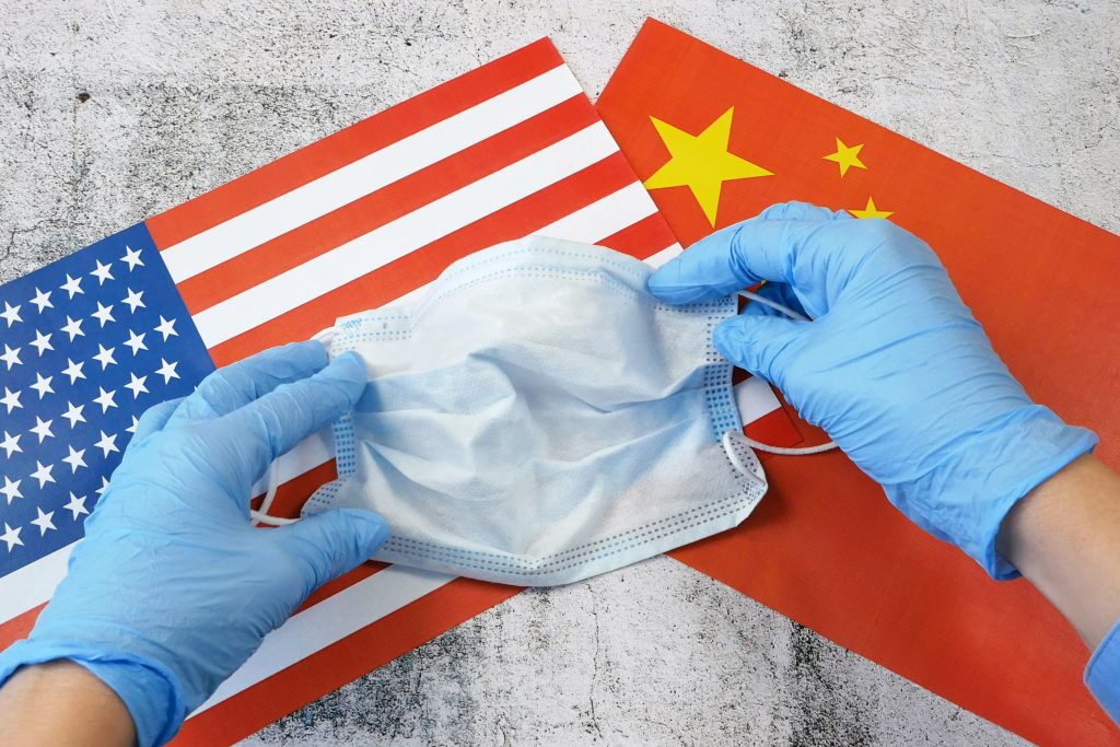 تصویری از پرچم چین در کنار پرچم آمریکا به همراه پزشکی با دستکش و ماسک برای عنوان شرایط تحصیل در چین در رشته پزشکی به زبان انگلیسی انتخاب شده است.