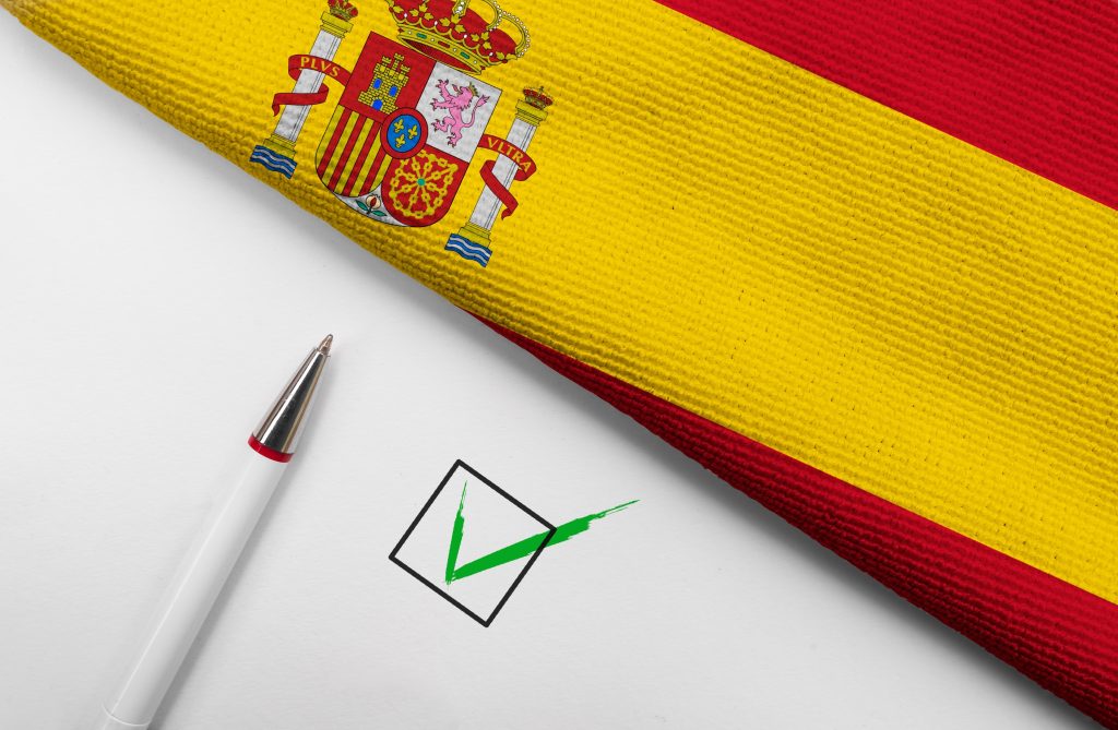 تصویری از پرچم اسپانیا در کنار خودکارو تیک برای عنوان تجربه‌ی  وکیل مهاجرت، حرف اول را می‌زند انتخاب شده است.