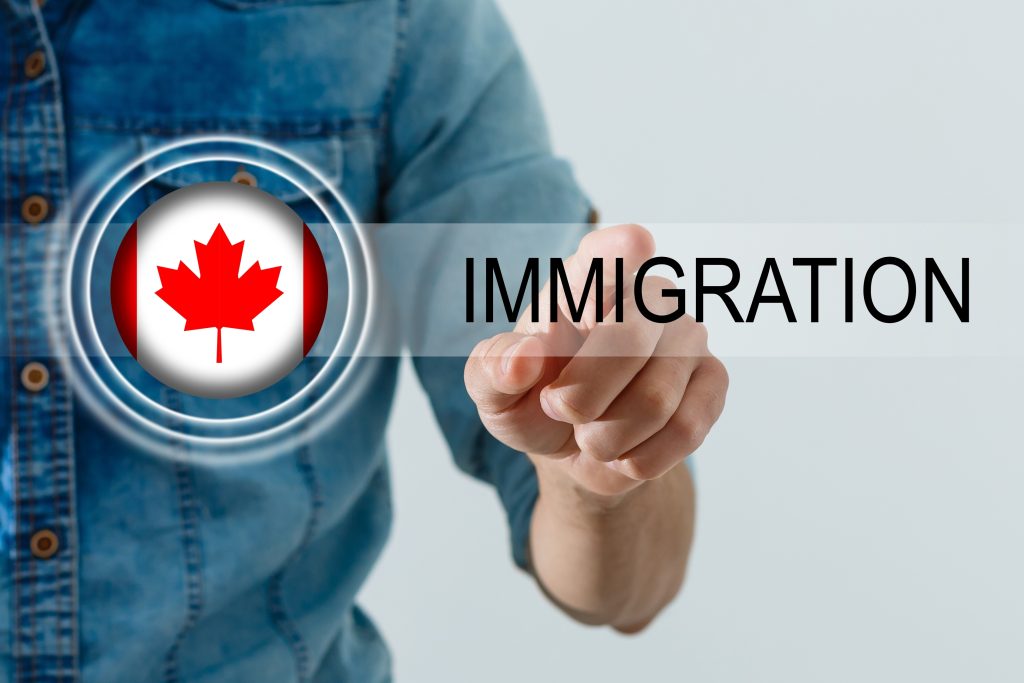 تصویری از فردی در حال اشاره به کلمه ی مهاجرت برای عنوان دلایل استخدام بهترین وکیل مهاجرت به کانادا انتخاب شده است
