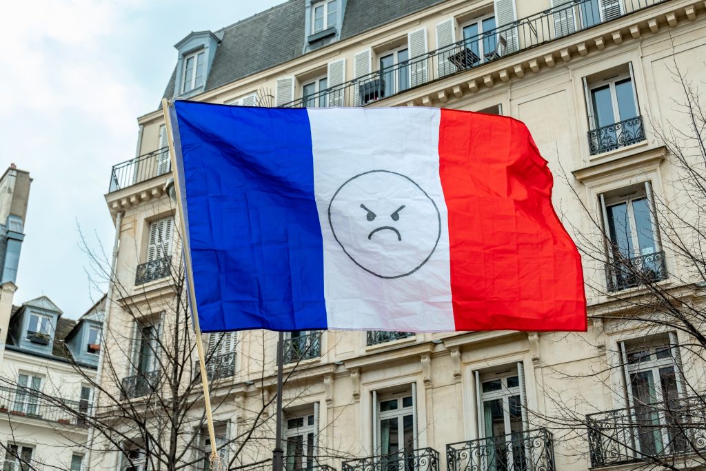 تصویری از صورتک ناراضی بر روی پرچم فرانسه برای عنوان اعتراضات بی‌پایان انتخاب شده است.