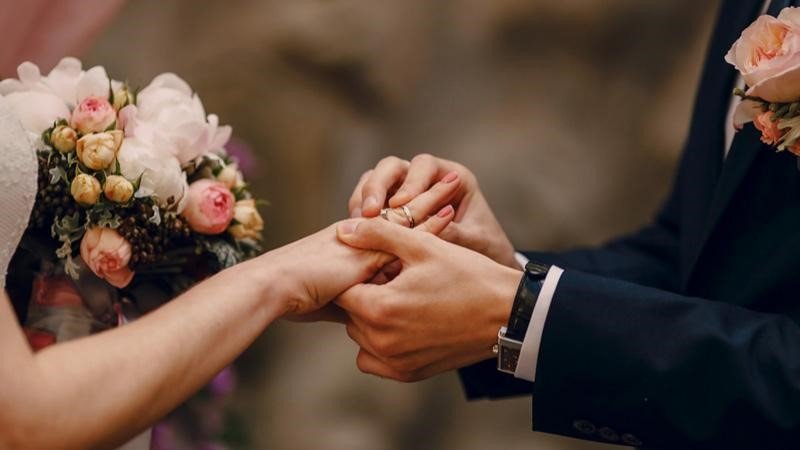 در این تصویر یک عروس و داماد به همراه حلقه و دسته گل برای عنوان مهاجرت به اسپانیا از طریق ازدواج انتخاب شده است.