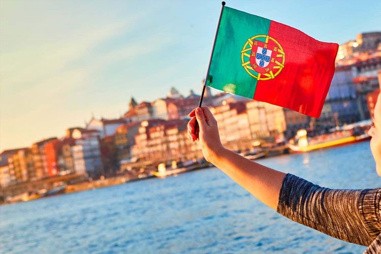 یک دختر به همراه پرچم پرتغال در دستش در یکی از شهرهای این کشور برای عنوان مزایای اقامت پرتغال انتخاب شده است.