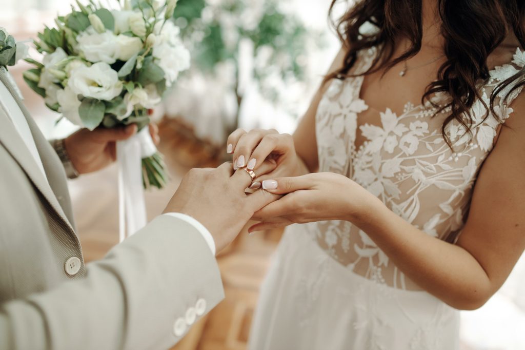 یک عروس و داماد و دسته‌ی گل در حال دست کردن حلقه های ازدواج برای عنوان أخذ اقامت پرتغال از طریق ازدواج انتخاب شده است.