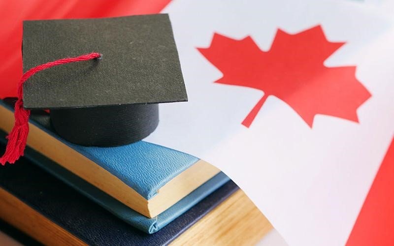 تصویری از کلاه فارع التحصیلی بر روی چندین کتاب به همراه پرچم کانادا برای عنوان مزایای تحصیل در مدارس کانادا انتخاب شده است.