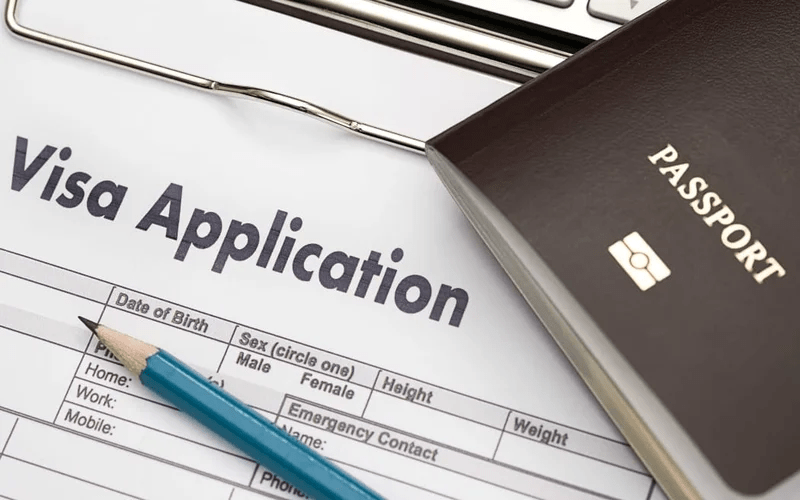 تصویری از فرم ویزا در کنار پاسپورت برای عنوان مدارک لازم برای اخذ اقامت فرانسه انتخاب شده است.