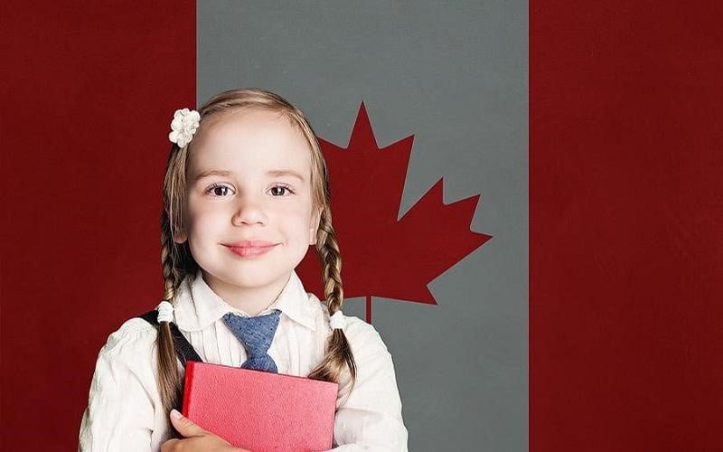 تصویری از دانش آموزی مقابل پرچم کانادا برای عنوان مراحل گرفتن ویزای تحصیلی در کانادا انتخاب شده است.
